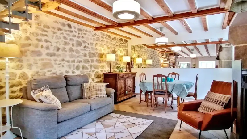 Cuisine moderne et cheminée de ferme traditionnelle avec poêle à bois au gîte Chez Amélie.